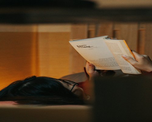 Person reading a book with soft warm lighting
